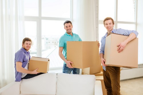 Movers carrying furniture near apartments in Highbury