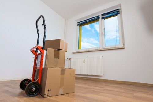 Professional movers carrying boxes from a Highbury apartment building